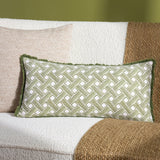 Alexa Reversible Cotton Cushion in olive green basket weave print, rectangular bolster shape with fringed edge, styled on a cream boucle sofa with a jute throw.