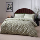 Alexa Cotton Abstract Duvet Cover Set in Olive, showing a geometric basket weave print duvet and matching pillowcases on a bed with a maroon headboard.