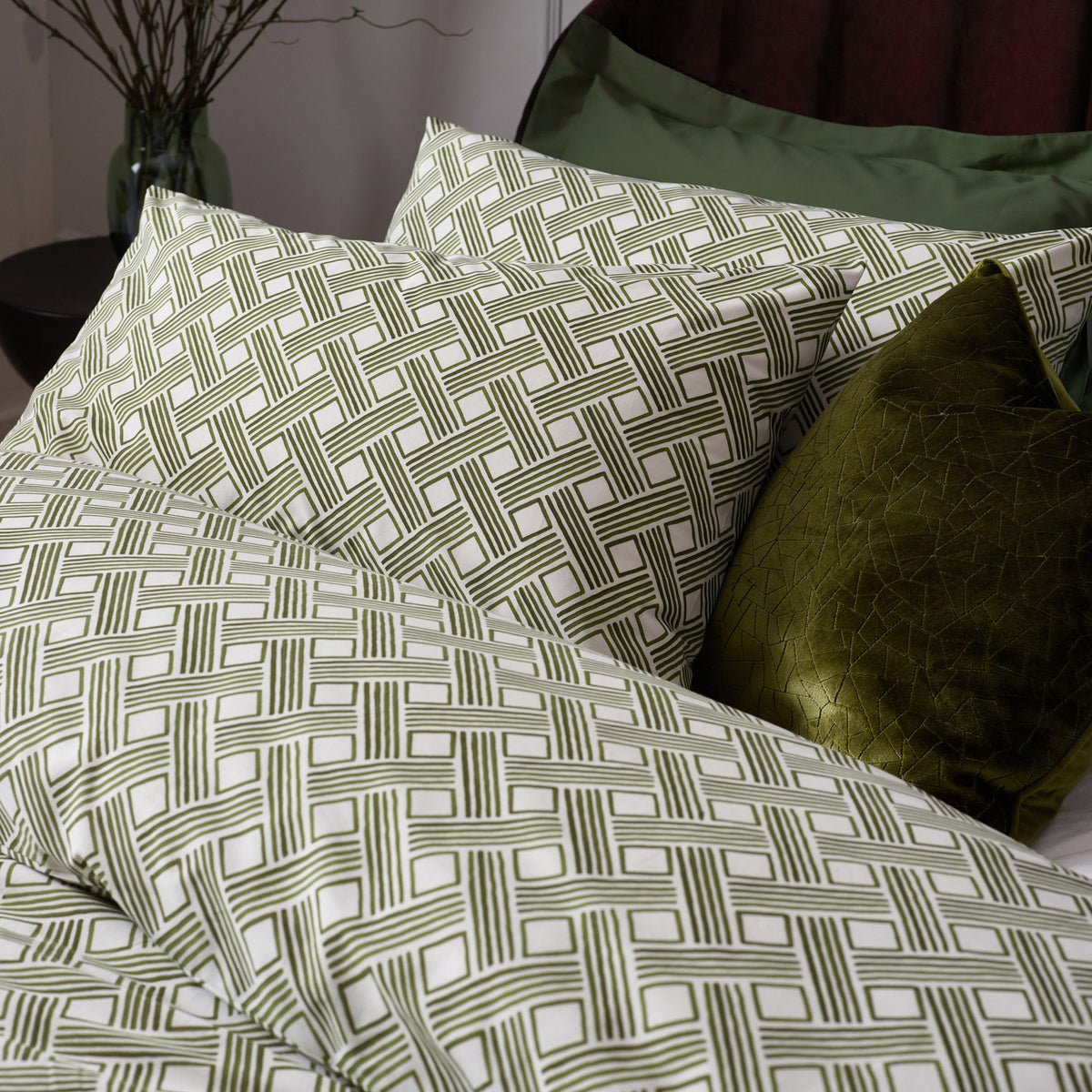 Alexa Cotton Abstract Duvet Cover Set in Olive, featuring a geometric basket weave print on cream cotton-rich fabric, styled with matching pillowcases and a solid olive velvet cushion.