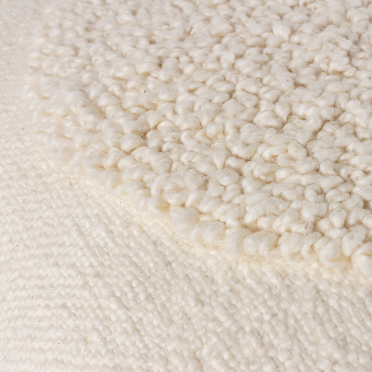 Close-up of the Almo Abstract Cotton Cushion in ecru, showing a densely tufted bouclé circle against a flat woven cotton ground.
