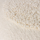 Close-up of the Almo Abstract Cotton Cushion in ecru, showing a densely tufted bouclé circle against a flat woven cotton ground.