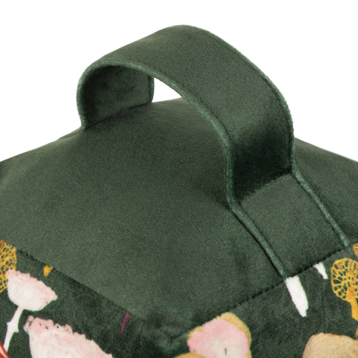 Amanita Abstract Velvet Door Stop in green, close-up of the carrying handle with mushroom-print fabric visible below, shown on a plain white background.