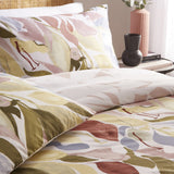 Amarosa Reversible Duvet Cover Set in Plaster with pillowcases, featuring a hand-painted leaf and petal print in clay, dusty pink, olive, gold, slate blue and terracotta on white.