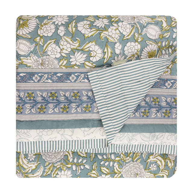 Annabelle Reversible Cotton Bedspread in blue, showing a scrolling floral design with patterned border on one side and a matching striped reverse, folded on a white background.