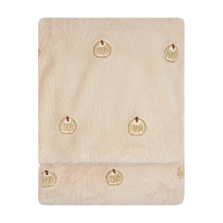 Folded natural beige faux fur throw with plush pile and small embroidered pumpkin motifs scattered across the surface, shown on a plain white background.