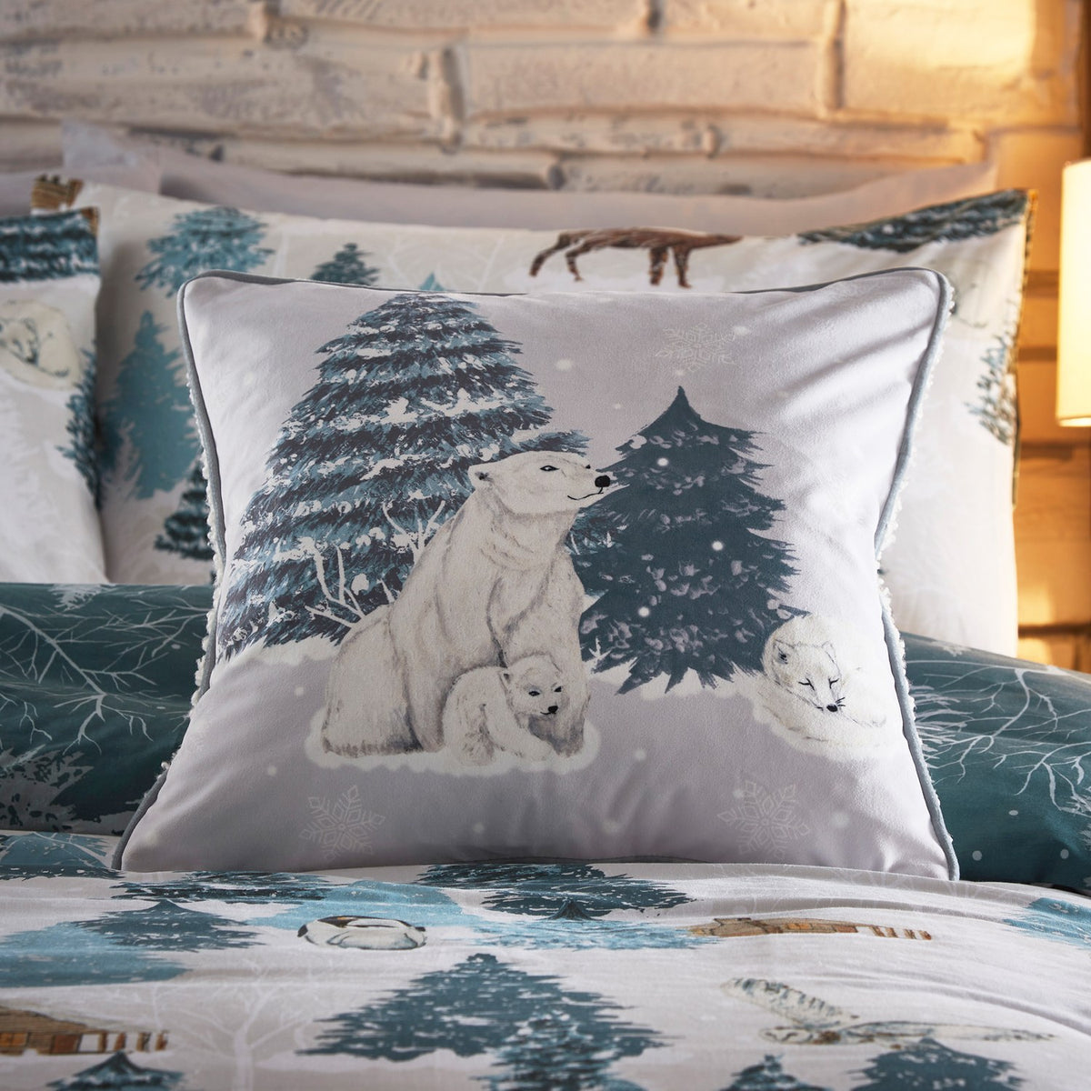 Arcticus Printed Animal Duvet Cover Set in blue, styled on a bed with a polar bear cub cushion, pine trees, and Arctic animal motifs in a bedroom setting.