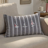 Abersoch Regatta rectangular cushion in navy striped cotton with cream and blue lines, featuring three embroidered sailboats, shown on a beige sofa.