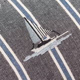 Close-up of the Abersoch Regatta cushion in navy, showing an embroidered sailboat in grey and cream thread on cotton fabric with cream and blue vertical stripes.