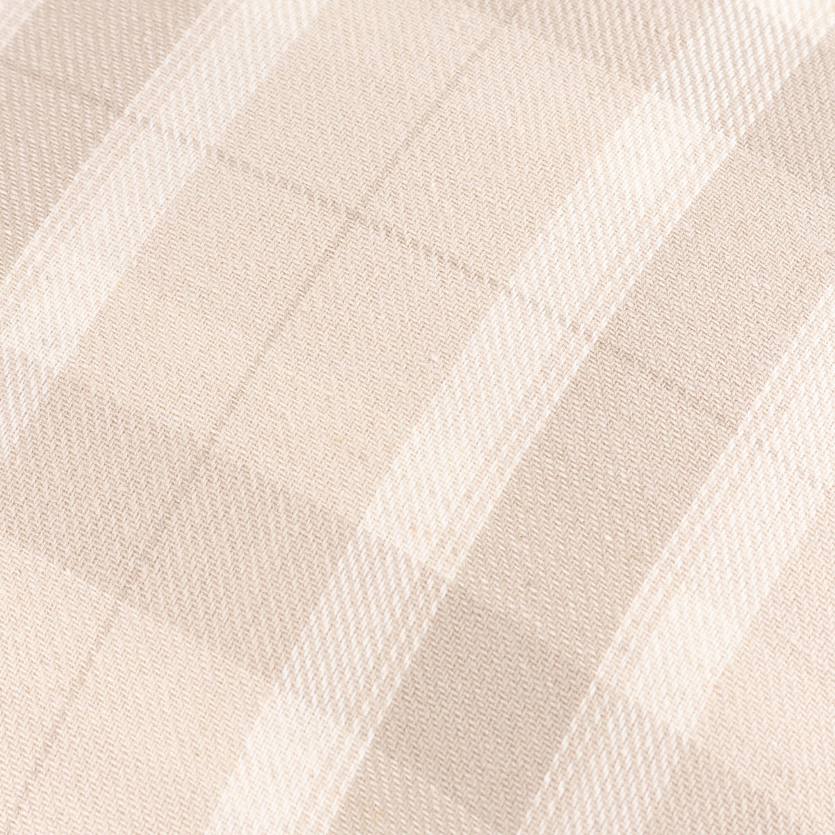 Close-up of the Arrochar Check Linen Cushion in Nut, showing a woven cotton-linen blend fabric with a yarn-dyed oatmeal and off-white check pattern.