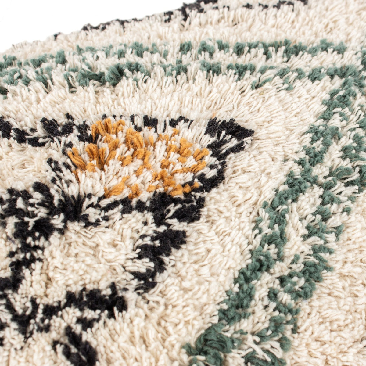 Close-up of the Atlas Tufted Cotton Cushion in ochre, showing high-pile tufted diamond and chevron pattern in cream, black, soft green and ochre.