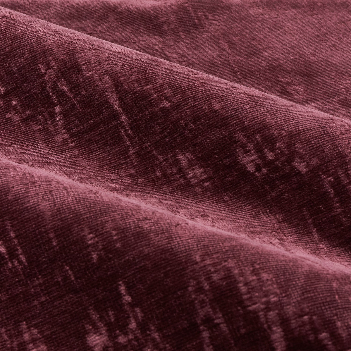 Close-up of Aurelio Chenille Jacquard eyelet curtain fabric in burgundy, showing soft folds and a subtle woven jacquard pattern with a dense, textured pile.