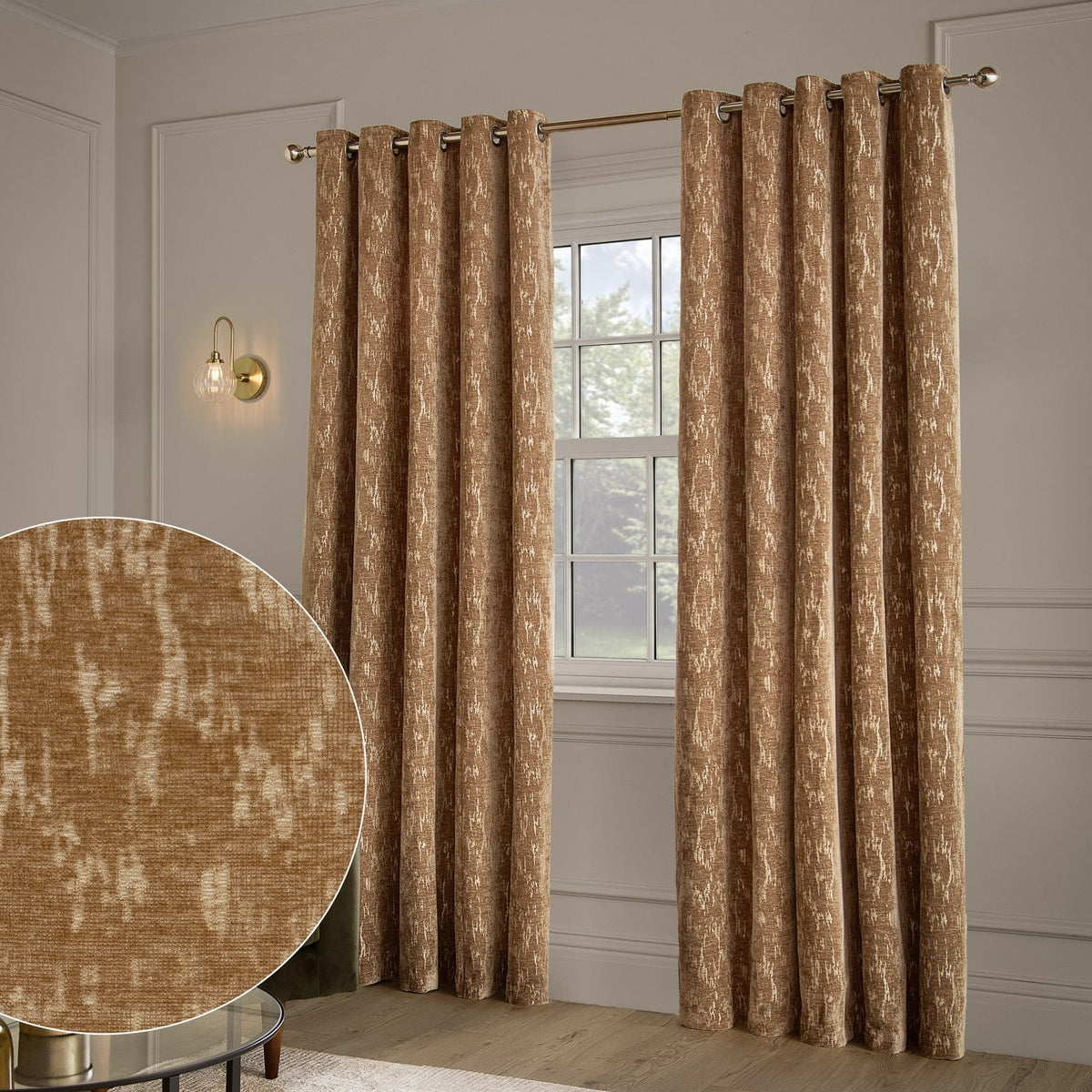 Aurelio Chenille Jacquard Fully Lined Eyelet Curtains in caramel, shown hanging on an eyelet pole beside a window, with a fabric swatch inset showing the mottled gold-toned jacquard texture.