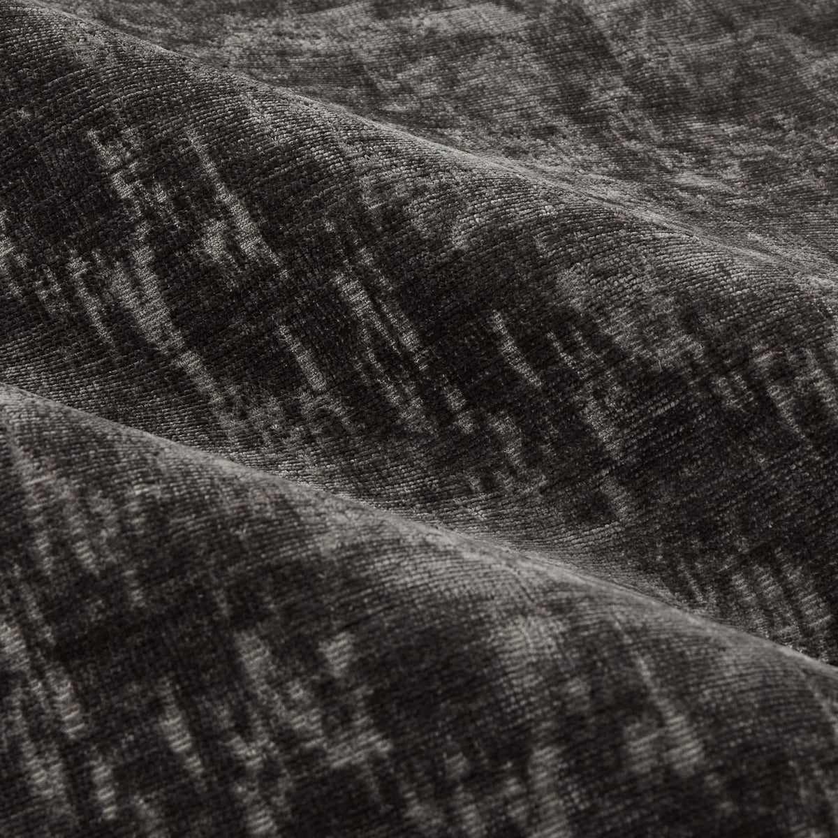 Close-up of Aurelio Chenille Jacquard Eyelet Curtain fabric in charcoal, showing a subtle abstract woven pattern with soft draped folds.