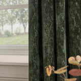 Aurelio Chenille Jacquard Eyelet Curtains in emerald, hung in folds by a window, showing the fabric's textured weave and subtle sheen against a soft interior setting.