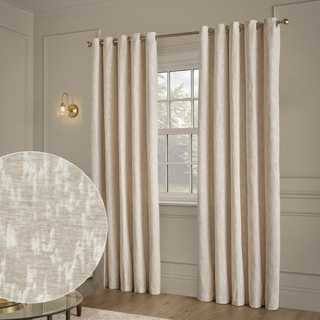 Ivory chenille jacquard eyelet curtains with abstract woven pattern, hung on a brass pole beside a window, with fabric texture swatch inset.