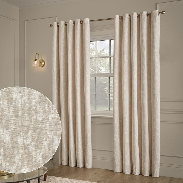 Ivory chenille jacquard eyelet curtains with abstract woven pattern, hung on a brass pole beside a window, with fabric texture swatch inset.
