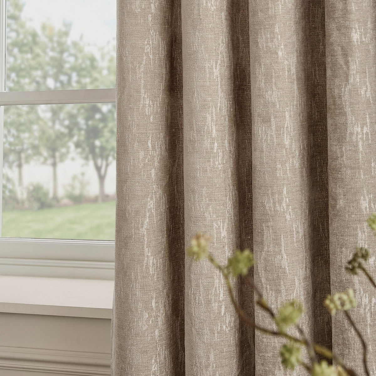 Aurelio Chenille Jacquard Fully Lined Eyelet Curtains in mink, shown draped by a window, with a soft abstract textured weave in warm greige with pale vertical flecks.