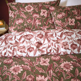 Autumn Garden reversible floral duvet cover set in rose, showing olive green botanical print with pink blooms and pumpkins on one side, reversing to a white ground with matching pillowcases.