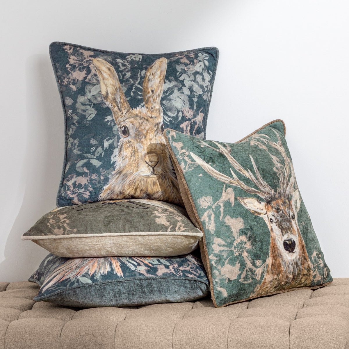 Avebury Animal Velvet Cushion in Navy featuring a hare portrait on floral velvet fabric, shown among matching stag and floral cushions in a home setting.