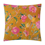 Aviary Velvet Cotton Cushion in gold, a square scatter cushion printed with pink peonies, daisies and perching birds on foliage, shown against a plain white background.