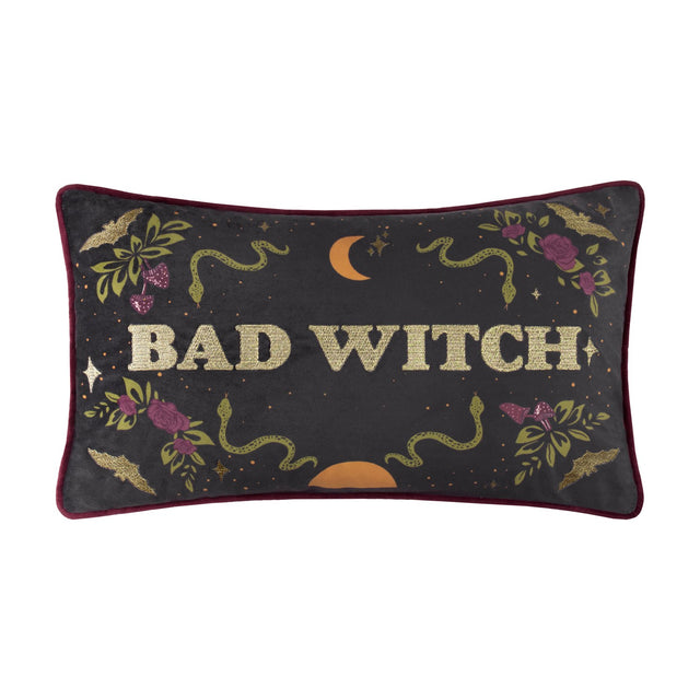 Rectangular velvet lumbar cushion in charcoal with burgundy piping, "Bad Witch" in gold embroidered lettering, surrounded by snakes, roses, bats and a crescent moon, on a white background.