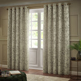 Bamboo Jacquard Lined Eyelet Curtains in champagne with grey bamboo pattern, hung on a bronze pole beside a French door in a living room setting.