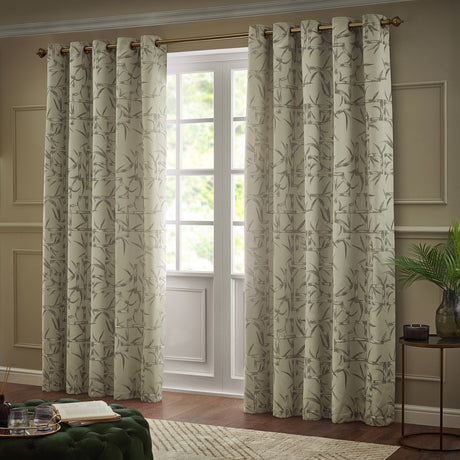 Bamboo Jacquard Lined Eyelet Curtains in champagne with grey bamboo pattern, hung on a bronze pole beside a French door in a living room setting.