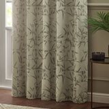 Bamboo Jacquard Lined Eyelet Curtains in champagne with grey bamboo pattern, hanging in a living room beside a window and side table.