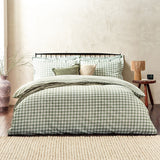Barton Cotton Gingham Duvet Cover Set in Forest, styled on a bed with matching pillowcases, green cushions and a ruffled sham, set against a neutral bedroom wall.