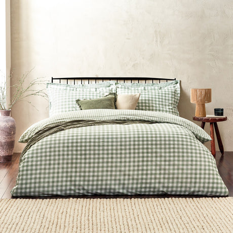 Barton Cotton Gingham Duvet Cover Set in Forest, styled on a bed with matching pillowcases, green cushions and a ruffled sham, set against a neutral bedroom wall.