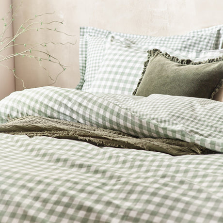 Barton Cotton Gingham Duvet Cover Set in Forest on a bedroom bed, green and white checked cotton with matching pillowcases, styled with olive velvet and linen cushions.