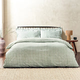 Barton Cotton Gingham Duvet Cover Set in Forest dressed on a bed with matching pillowcases, styled in a bedroom with a black metal headboard and wooden side table.