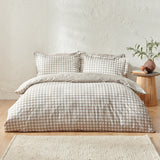 Barton Cotton Gingham Duvet Cover Set in Natural on a bed with matching pillowcases, styled in a bedroom with a wooden side stool and woven rug.