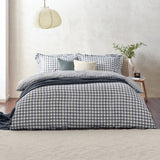 Barton Cotton Gingham Duvet Cover Set in Navy dressing a bed with matching pillowcases, styled with a grey throw, cushions, and a bedroom setting.
