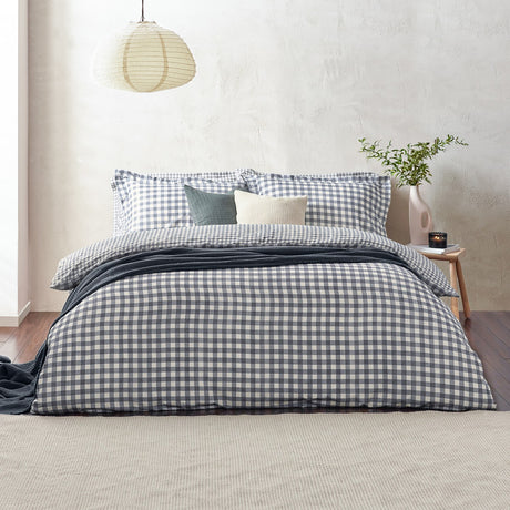 Barton Cotton Gingham Duvet Cover Set in Navy dressing a bed with matching pillowcases, styled with a grey throw, cushions, and a bedroom setting.