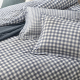 Barton Cotton Gingham Duvet Cover Set in Navy, shown with matching pillowcases featuring a navy and cream check pattern with flanged edges on a bed.