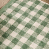 Close-up of the Barton Gingham Cotton Bath Mat in forest green, showing the yarn-dyed check pattern in green and cream cotton pile.