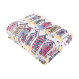 Folded Beach Huts Printed Polyester Throw in multicoloured coastal design, showing pink, blue, yellow and lilac beach hut illustrations on cream fleece fabric, shot on a white background.