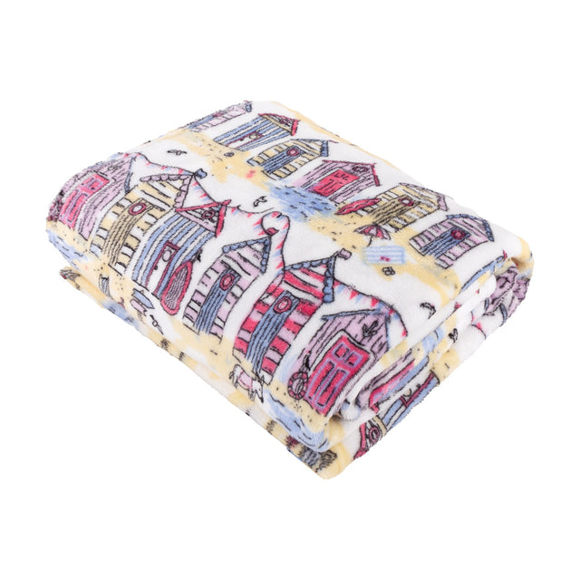 Folded Beach Huts Printed Polyester Throw in multicoloured coastal design, showing pink, blue, yellow and lilac beach hut illustrations on cream fleece fabric, shot on a white background.
