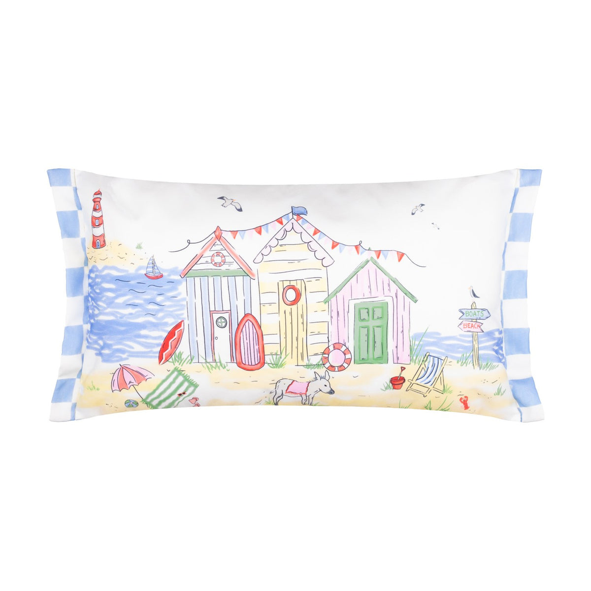Rectangular polyester cushion with a hand-painted beach scene featuring colourful huts, a lighthouse, sailing boat, bunting and a dog on sand, blue-and-white striped side trim, on a white background.
