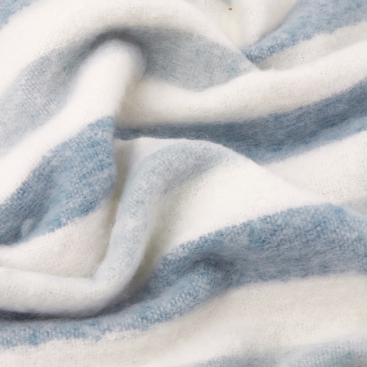 Close-up of the Beechwood Striped Polyester Throw in sky blue and cream, showing soft woven fabric folds in a heathered stripe pattern.