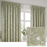 Bella fully lined cotton pencil pleat curtains in sage green with a white outline floral peony pattern, shown hanging beside a bright window with a floral arrangement, alongside a fabric swatch.