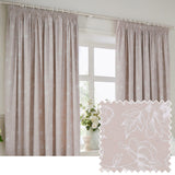 Bella fully lined cotton pencil pleat curtains in natural, shown hanging by a window with white pleated header tape and a white outline floral print, alongside a matching fabric swatch.