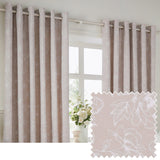 Bella Cotton Fully Lined Eyelet Curtains in Natural, shown as a pair on a metal pole beside a window, with white floral line-work on a soft natural ground and fabric swatch inset.