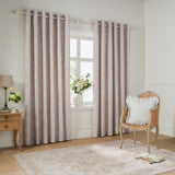 Bella Cotton Fully Lined Eyelet Curtains in Natural hanging either side of a window in a living room, showing floral white line-work on a soft natural ground with eyelet heading.