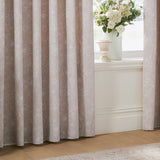 Bella Cotton Fully Lined Eyelet Curtains in Natural, floral line-print fabric framing a window with a vase of white flowers on the sill in a living room setting.