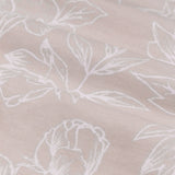 Close-up of Bella cotton eyelet curtain fabric in natural, showing fine white line-drawn floral and leaf outlines on a woven natural-toned ground.