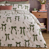 Belle Stripe Reversible Bows Duvet Cover Set in Evergreen, cream pinstripe fabric with green ribbon bow print, shown dressing a bed in a bedroom setting.