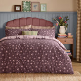 Belle Stripe Reversible Bows Duvet Cover Set in Rosewood, styled on a bed with a floral pattern and pink pinstripe reverse, matching pillowcases, in a bedroom setting.