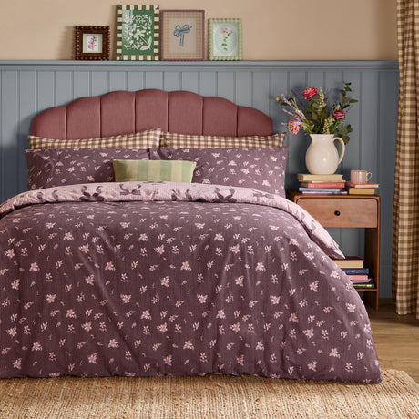 Belle Stripe Reversible Bows Duvet Cover Set in Rosewood, styled on a bed with a floral pattern and pink pinstripe reverse, matching pillowcases, in a bedroom setting.